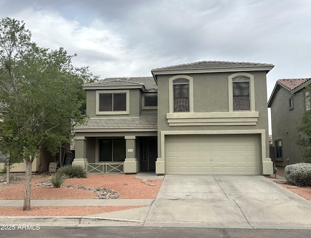 8514 S 49th Dr, Laveen, AZ 85339 - view of front of house with concrete driveway, a garage, stucco siding, and covered porch