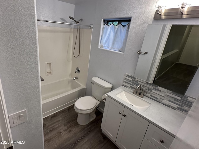8514 S 49th Dr, Laveen, AZ 85339 - full bathroom featuring a textured wall, wood finished floors, toilet, vanity, and decorative backsplash