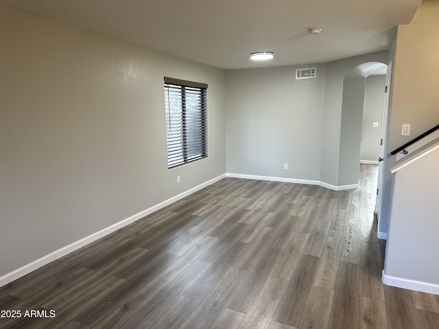 8514 S 49th Dr, Laveen, AZ 85339 - empty room with arched walkways, dark wood-style floors, baseboards, and a smoke detector