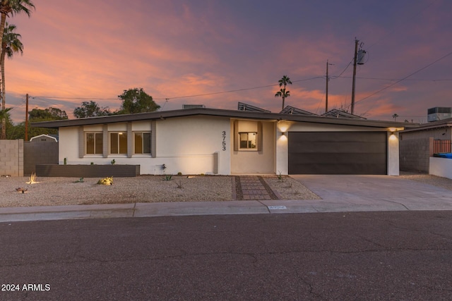 view of front of property featuring central AC unit and a garage