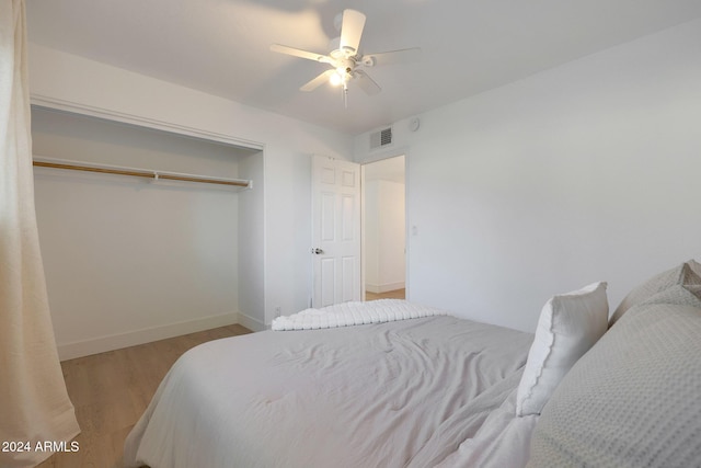 bedroom featuring ceiling fan, a closet, and light wood-type flooring