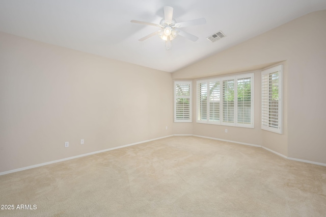 unfurnished room with light colored carpet, a ceiling fan, baseboards, vaulted ceiling, and visible vents