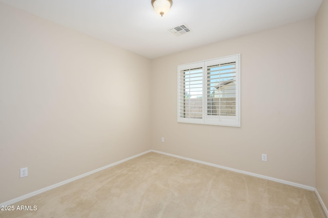 spare room with baseboards, light carpet, and visible vents
