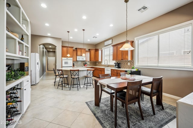 8417 W Northview Ave, Glendale, AZ 85305 - dining room featuring arched walkways, recessed lighting, light tile patterned floors, and baseboards