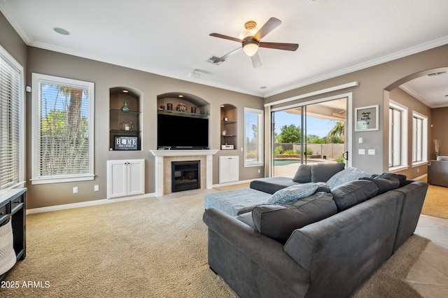 8417 W Northview Ave, Glendale, AZ 85305 - living area with arched walkways, ceiling fan, built in shelves, ornamental molding, and a tile fireplace