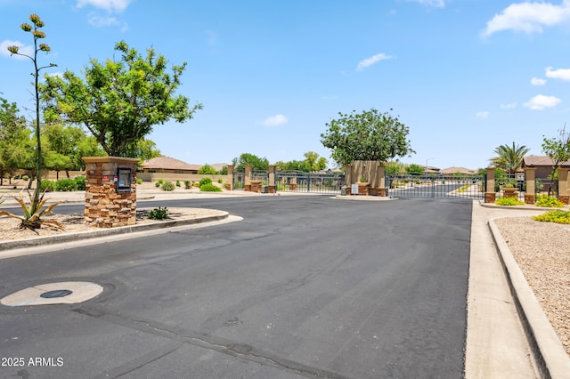 8417 W Northview Ave, Glendale, AZ 85305 - view of asphalt road featuring a gate, a gated entry, curbs, and street lighting