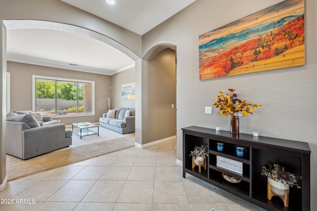 8417 W Northview Ave, Glendale, AZ 85305 - living room featuring arched walkways, baseboards, crown molding, light tile patterned floors, and light colored carpet