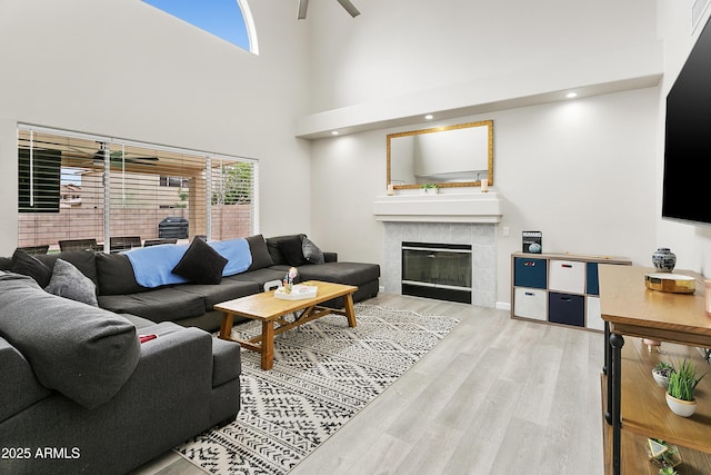 3126 W Stephens Pl, Chandler, AZ 85226 - living room featuring wood finished floors, a tile fireplace, ceiling fan, and a high ceiling