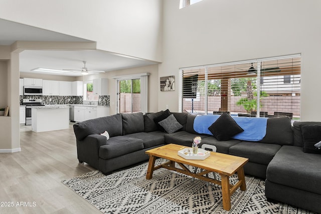 3126 W Stephens Pl, Chandler, AZ 85226 - living room featuring ceiling fan, light wood-type flooring, and a towering ceiling