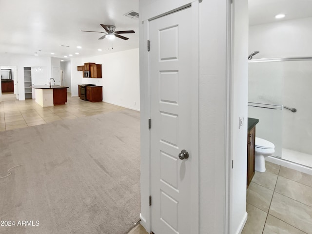 hallway with light carpet and sink