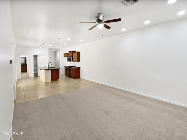 unfurnished living room featuring ceiling fan, light colored carpet, and sink