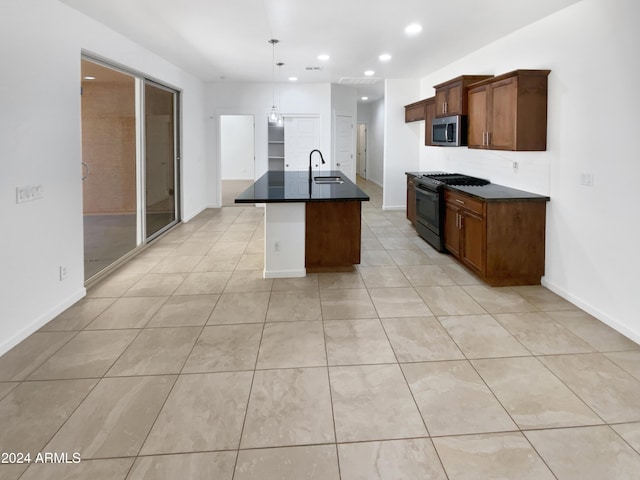 kitchen featuring sink, black range with gas cooktop, pendant lighting, a kitchen island with sink, and light tile patterned floors