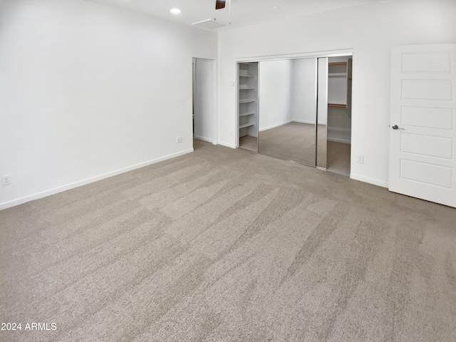 unfurnished bedroom featuring carpet, a closet, and ceiling fan