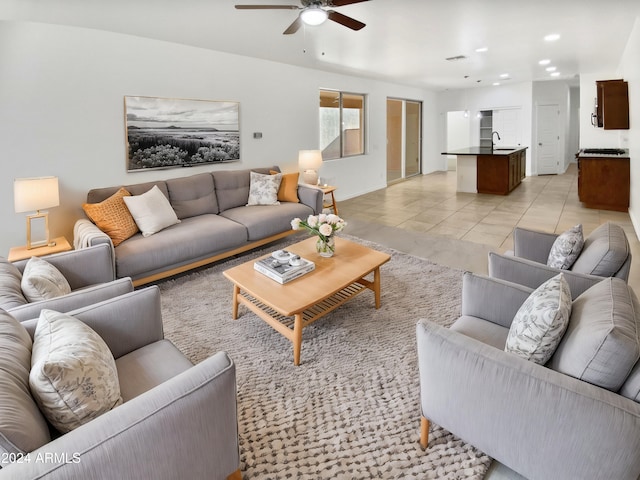 tiled living room featuring ceiling fan and sink