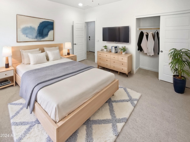 bedroom with light carpet and a closet