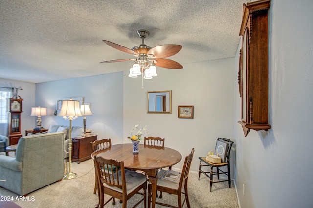 dining area featuring light carpet, a textured ceiling, and ceiling fan