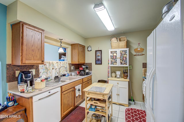 kitchen featuring backsplash, sink, pendant lighting, and white appliances