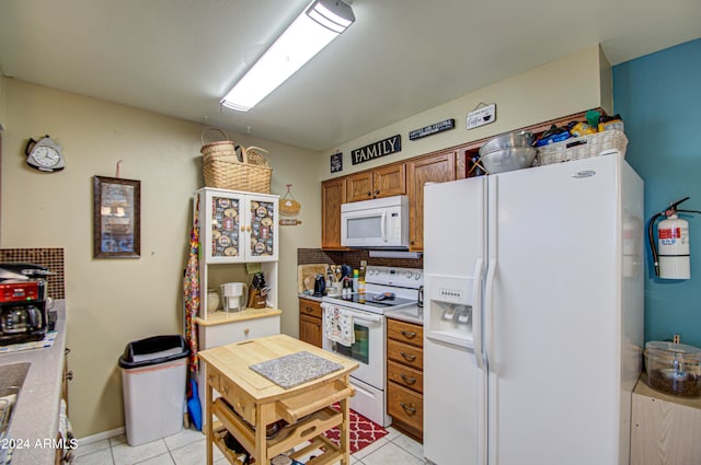 kitchen with light tile patterned floors and white appliances