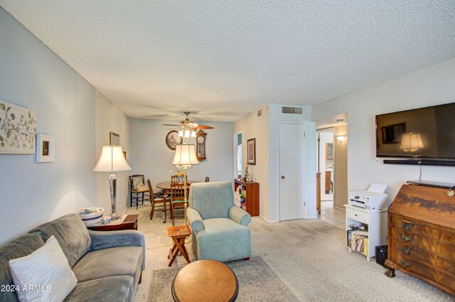 carpeted living room with a textured ceiling and ceiling fan