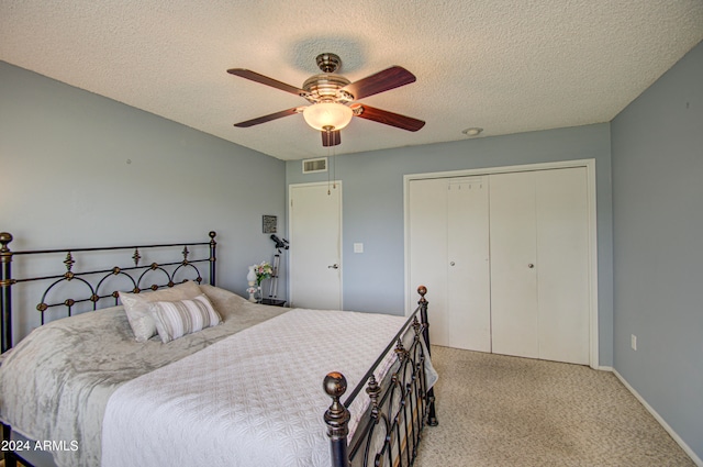 carpeted bedroom with a textured ceiling, a closet, and ceiling fan