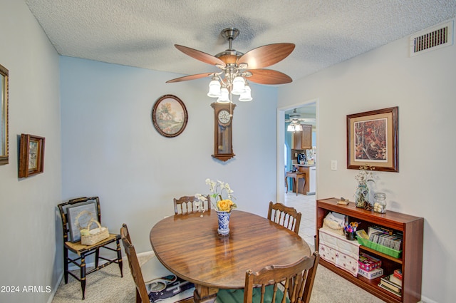 dining area featuring light carpet, a textured ceiling, and ceiling fan