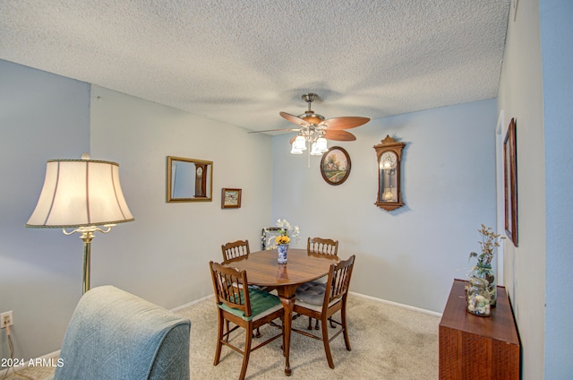 carpeted dining area with ceiling fan and a textured ceiling