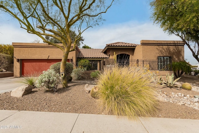 view of front of property with stucco siding, driveway, an attached garage, and a tile roof