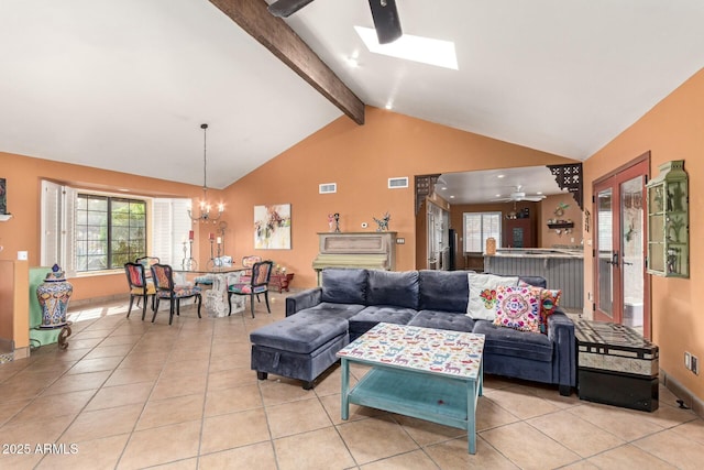 living room with visible vents, beamed ceiling, light tile patterned flooring, and ceiling fan with notable chandelier