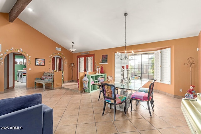 dining room with arched walkways, light tile patterned floors, and beam ceiling