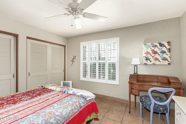 bedroom with light tile patterned floors, a ceiling fan, and baseboards