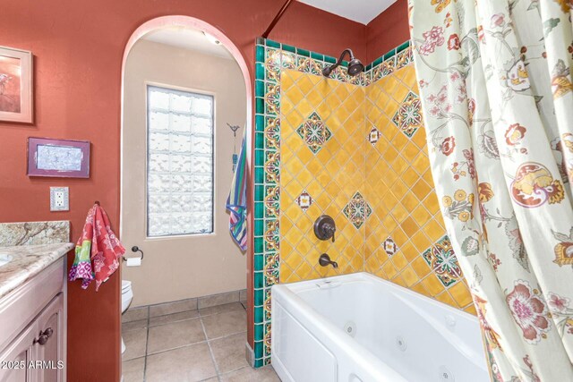 full bath featuring a wealth of natural light, toilet, a combined bath / shower with jetted tub, tile patterned flooring, and vanity