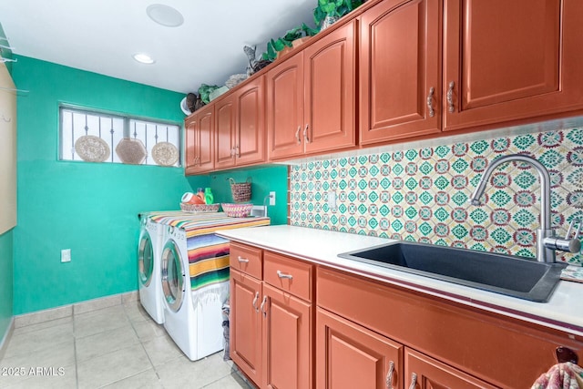 clothes washing area featuring a sink, cabinet space, separate washer and dryer, and light tile patterned flooring