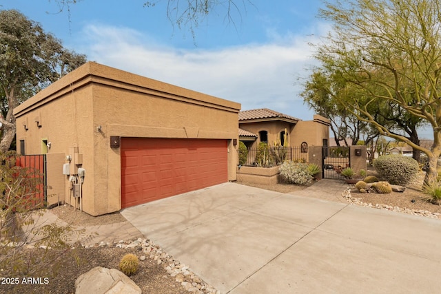 view of front facade featuring stucco siding, fence, driveway, and a gate