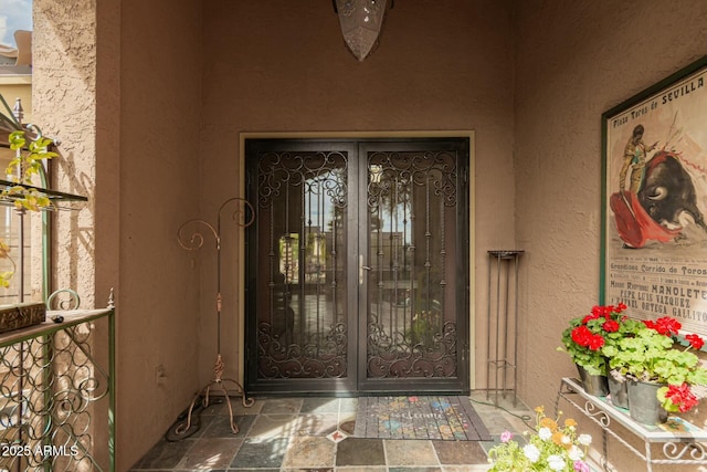 entrance to property featuring stucco siding