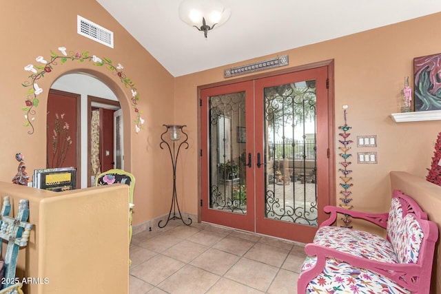 entrance foyer with visible vents, lofted ceiling, light tile patterned floors, french doors, and arched walkways