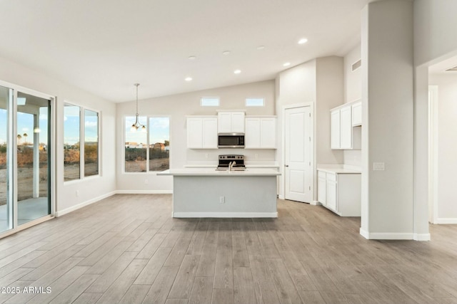 kitchen with light wood-type flooring, white cabinetry, stainless steel appliances, and light countertops