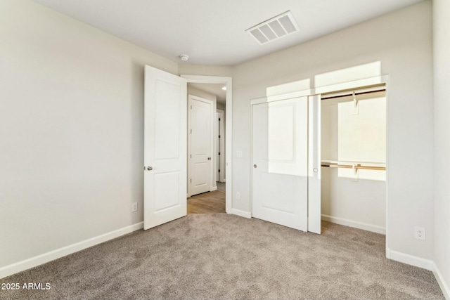 unfurnished bedroom featuring baseboards, a closet, visible vents, and carpet flooring