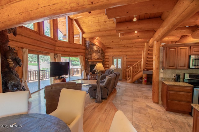 6168 W Hidden Pines Loop, Pine, AZ 85544 - living area featuring log walls, wooden ceiling with exposed beams, stairway, high vaulted ceiling, and a stone fireplace