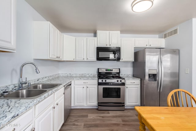 kitchen featuring light stone counters, dark wood-type flooring, sink, white cabinetry, and appliances with stainless steel finishes