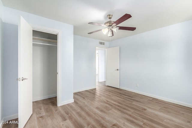 unfurnished bedroom featuring ceiling fan, light hardwood / wood-style flooring, and a closet