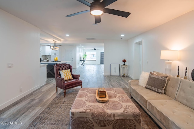 living room featuring ceiling fan and light hardwood / wood-style floors