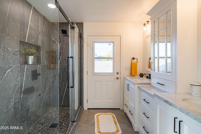 bathroom featuring tile patterned floors, an enclosed shower, and vanity