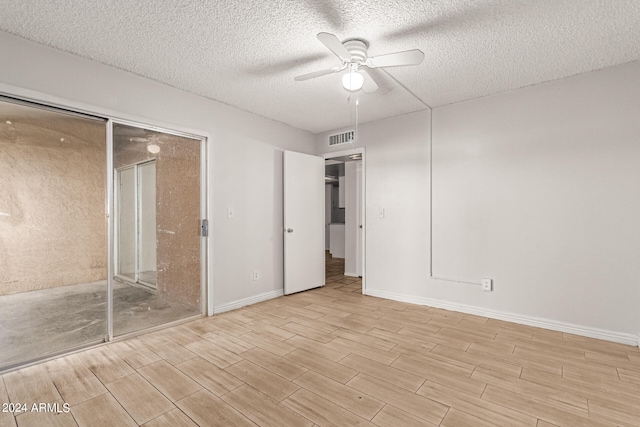 spare room with light hardwood / wood-style flooring, a textured ceiling, and ceiling fan