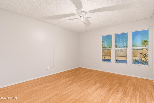 spare room with ceiling fan, a textured ceiling, and light hardwood / wood-style floors