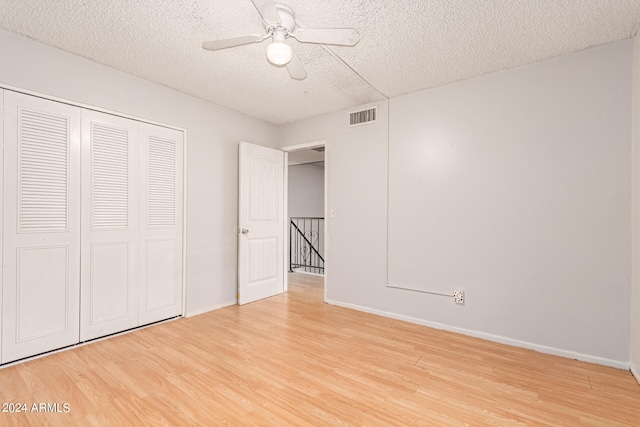 unfurnished bedroom featuring a closet, hardwood / wood-style floors, a textured ceiling, and ceiling fan