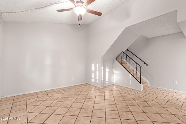 tiled spare room featuring ceiling fan and a textured ceiling