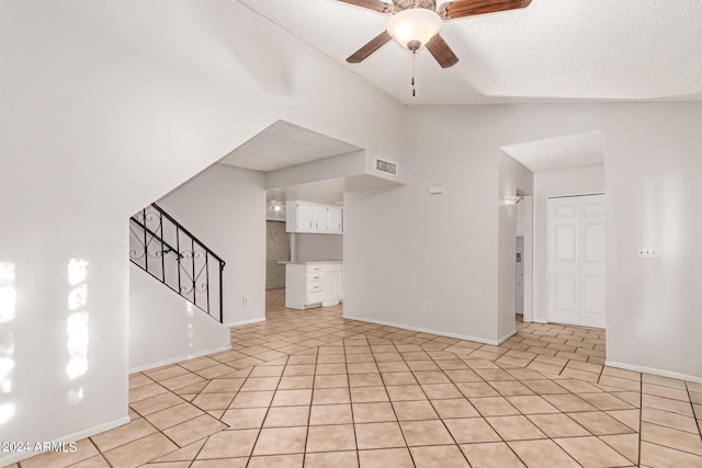 interior space with light tile patterned flooring, ceiling fan, and a textured ceiling