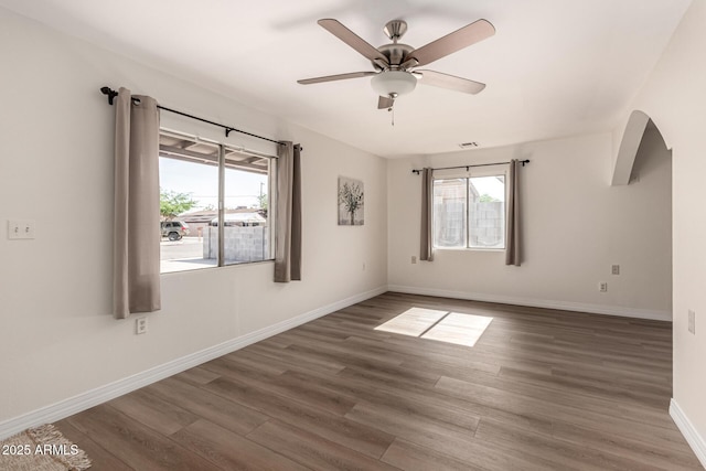 1113 E 5th St, Casa Grande, AZ 85122 - unfurnished room featuring healthy amount of natural light, wood finished floors, ceiling fan, and arched walkways