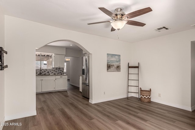 1113 E 5th St, Casa Grande, AZ 85122 - spare room with arched walkways, a ceiling fan, and dark wood finished floors
