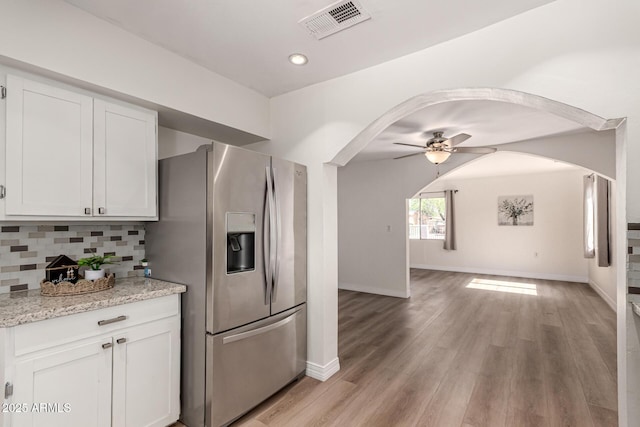 1113 E 5th St, Casa Grande, AZ 85122 - kitchen featuring stainless steel fridge with ice dispenser, arched walkways, ceiling fan, tasteful backsplash, and white cabinets